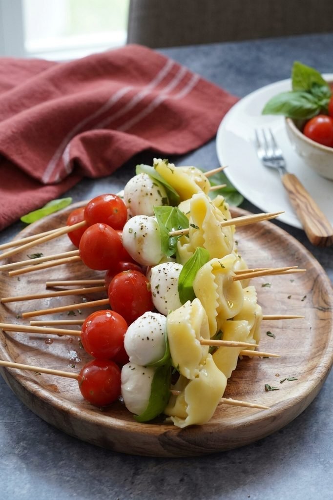 Tortellini caprese skewers with fresh cherry tomatoes, mozzarella balls, basil and tortellini.